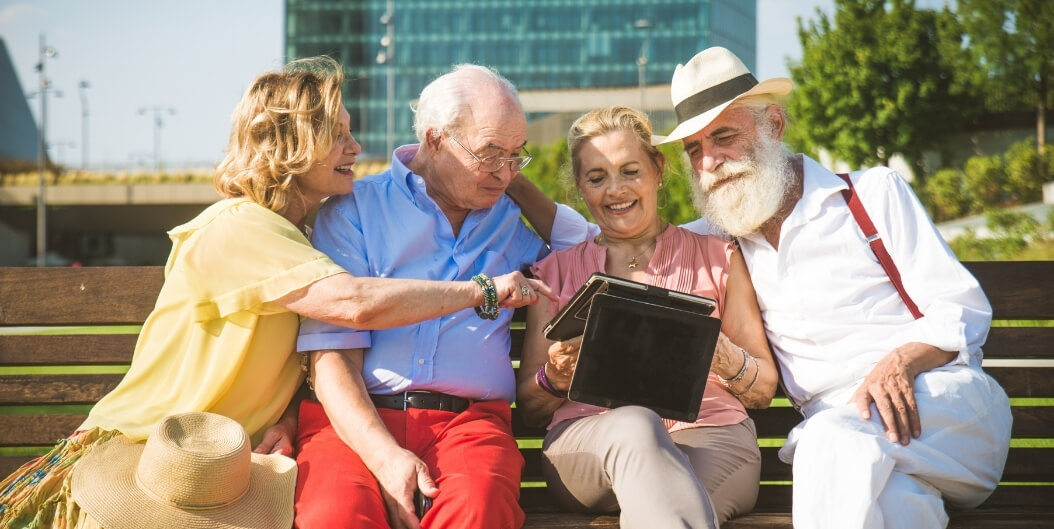 Seniors Reviewing Floor Plans on Tablet Outdoors at Independent Living Facility