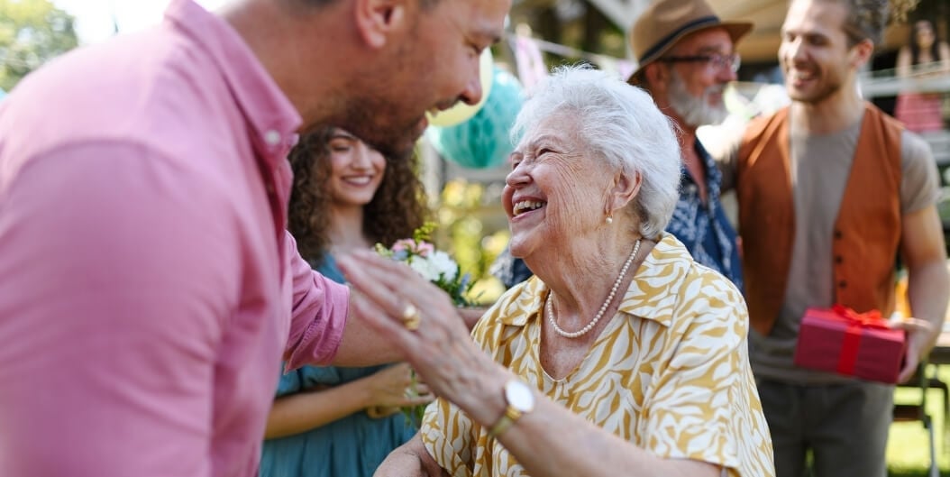 Senior Woman Celebrating Outdoors with Family at an Assisted Living Facility