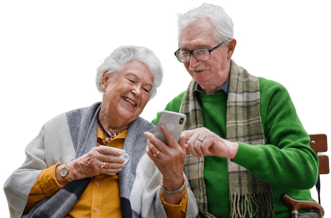 Elderly Couple Smiling While Looking at a Smartphone Together in Independent Living Elderly Couple Smiling While Looking at a Smartphone Together in Independent Living