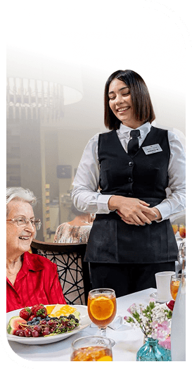 Smiling Server Assisting an Elderly Woman During Lunch at an Independent Living Community