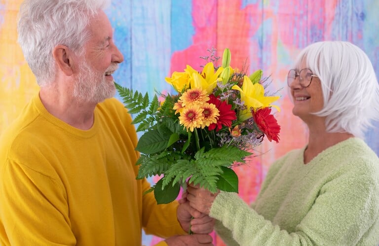 Elderly Man Surprising His Wife With a Colorful Bouquet in Independent Living