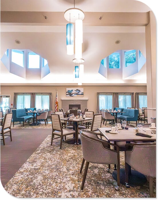 Elegant Dining Room with Pendant Lighting and Stone Fireplace at an Independent Living Facility Elegant Dining Room with Pendant Lighting and Stone Fireplace at an Independent Living Facility
