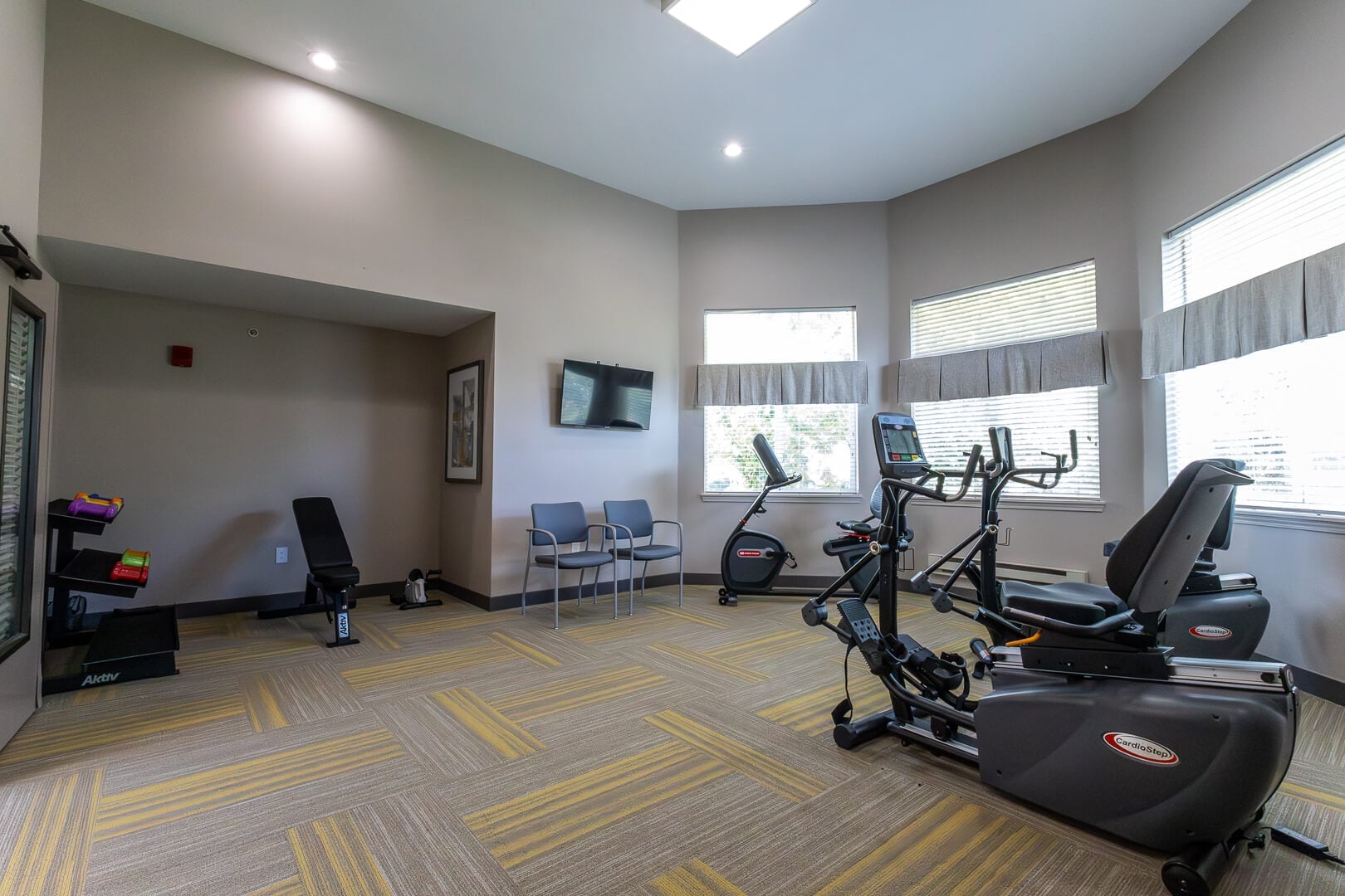 Sunlit Fitness Room with Elliptical and Cardio Equipment at an Independent Living Facility