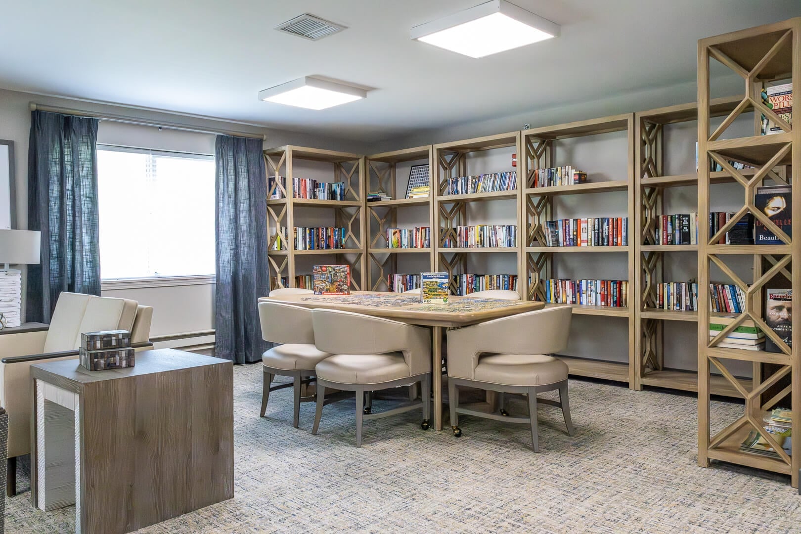 Bright Library Nook with Open Bookshelves and Round Table at an Independent Living Community
