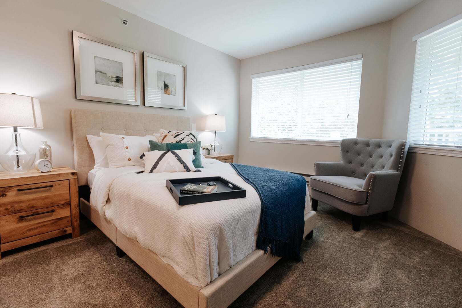 Warmly Decorated Resident Bedroom with Upholstered Headboard and Armchair at an Independent Living Facility