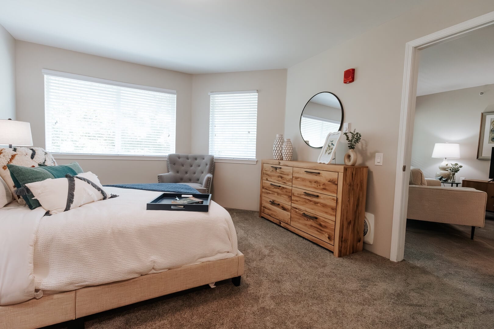 Spacious Resident Bedroom with Wooden Dresser and Large Windows at an Independent Living Community